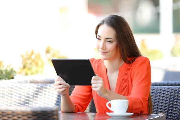 Serious woman watching tablet online content in a bar — Stock Photo, Image