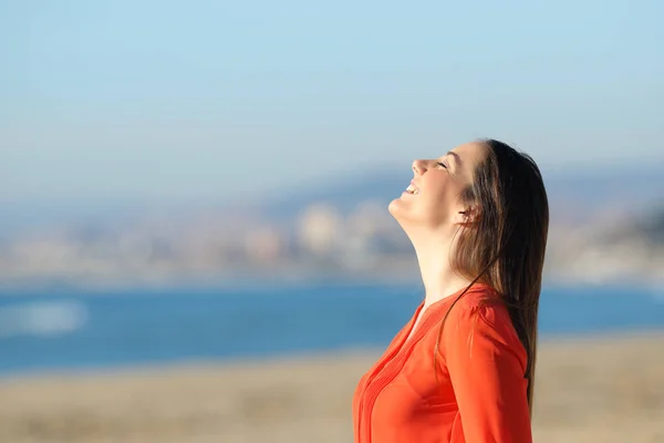 Frau in Orange atmet frische Luft am Strand — Stockfoto