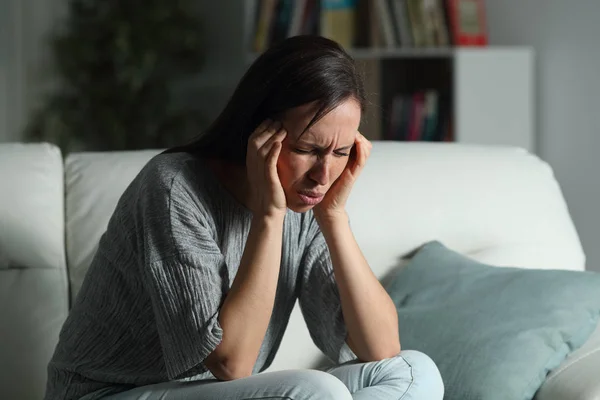 Mujer en casa sufriendo migraña en la noche —  Fotos de Stock