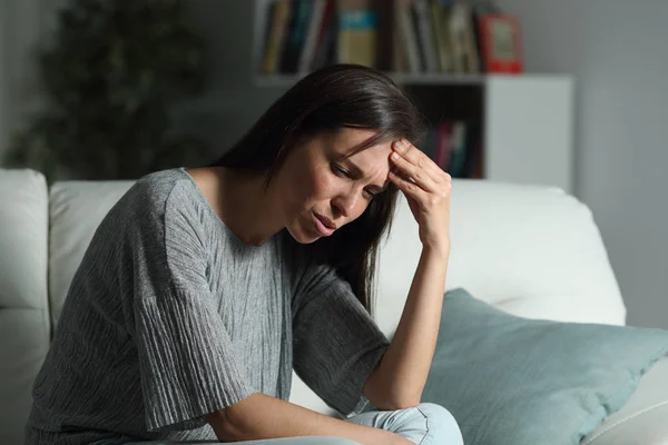 Mujer en casa sufriendo dolor de cabeza en la noche —  Fotos de Stock