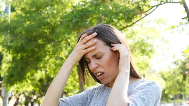 公園で苦しむ頭痛を訴える大人の女性 — ストック動画