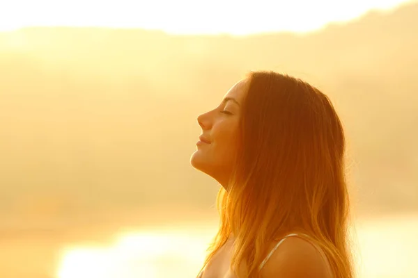Profil einer Frau bei Sonnenuntergang, die frische Luft atmet — Stockfoto