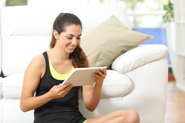 Happy sportswoman using a tablet to find tutorials — Stock Photo, Image