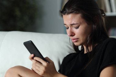 Telefon mesajını okuduktan sonra ağlayan üzgün genç