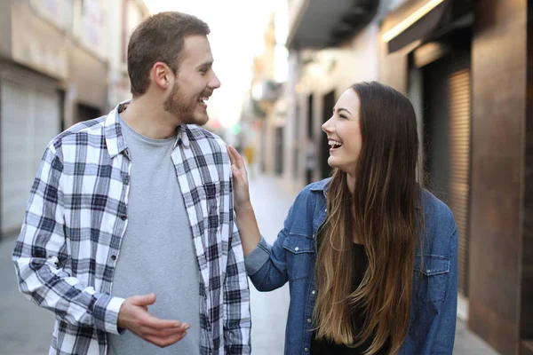 Amici felici che flirtano camminando verso di te per strada — Foto Stock