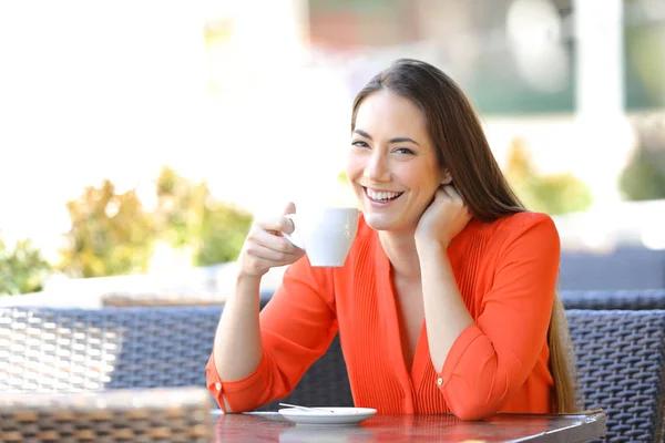 Lycklig kvinna tittar på du håller kaffe Mugg i en bar — Stockfoto