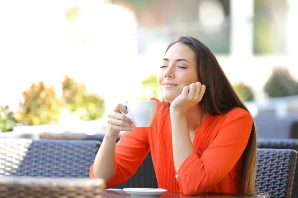 Relaxed woman enjoying smelling coffee in a bar — Stock Photo, Image