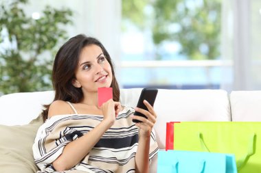 Kredi kartı tutan satışları düşünen mutlu alışverişçi