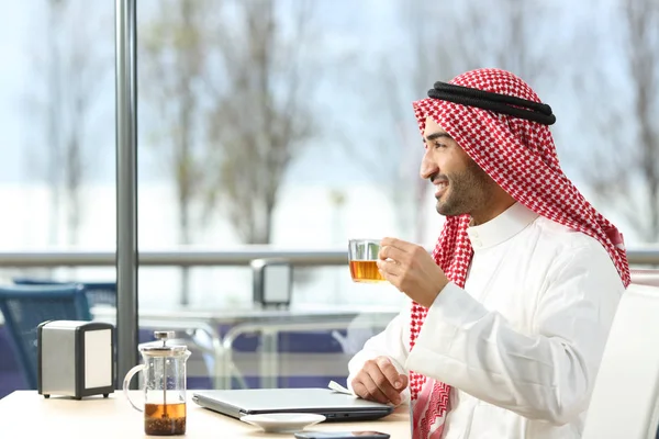 Happy arab man looking away holding a tea cup — Stock Photo, Image