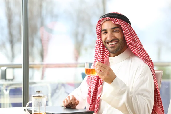 Happy arab man holding a cup of tea looking at camera — Stock Photo, Image