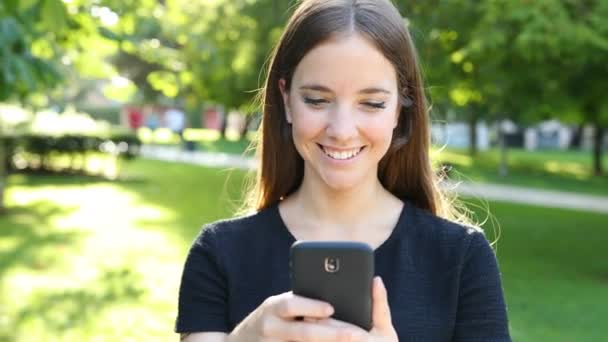 Front View Happy Woman Walking Camera Park Using Smart Phone — Stock Video