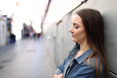 Yalnız bir sokakta bir duvara yaslanmış şikayet üzgün kız