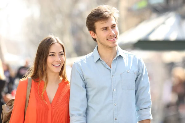 Couple or friends walking in the street looking at side — Stock Photo, Image