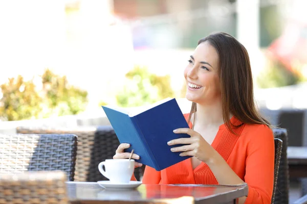 Gelukkige vrouw het lezen van een boek dromen in een koffieshop — Stockfoto