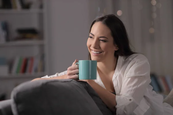 Pensive femme boit du café en regardant côté dans la nuit à la maison — Photo