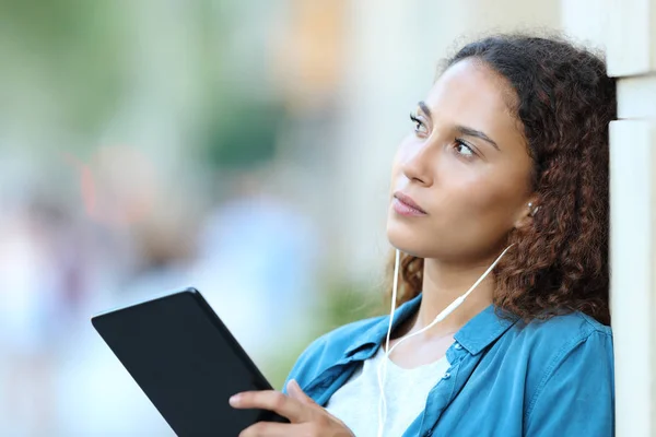 Mujer seria de raza mixta pensando en escuchar música — Foto de Stock