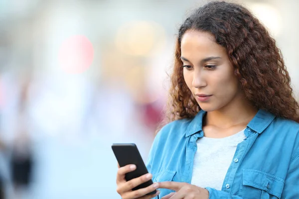 Mixed race woman using smart phone in the street — Stock Photo, Image