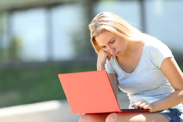 Estudante frustrado estudando usando laptop em um campus — Fotografia de Stock