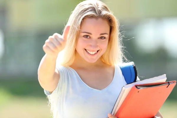 Щасливий студент позує з великими пальцями в кампусі — стокове фото