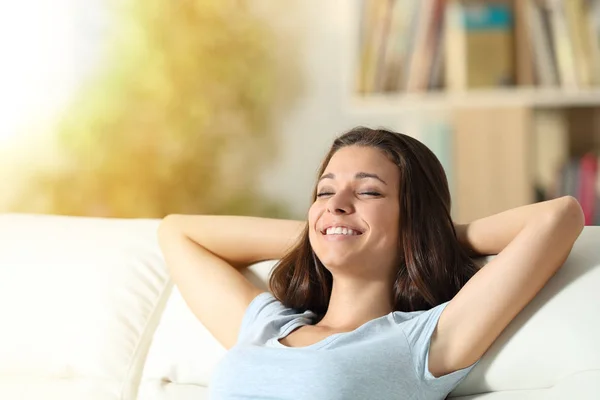 Счастливая расслабленная девушка отдыхает дома на диване — стоковое фото