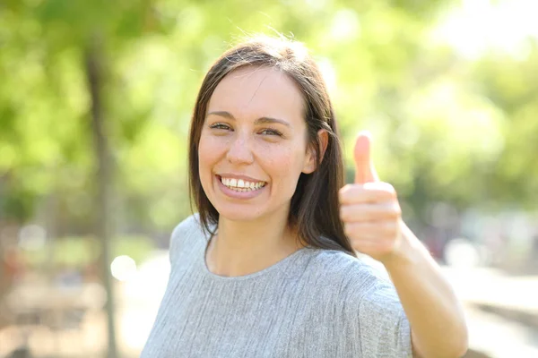 Glückliche Frau blickt mit erhobenem Daumen in die Kamera — Stockfoto