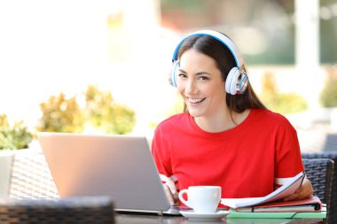 Mutlu öğrenci e-öğrenme bir barda kamera bakarak