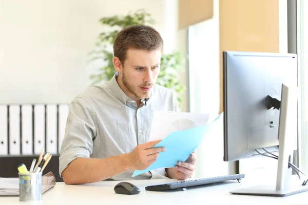 Shocked businessman checking documents at office — Stock Photo, Image