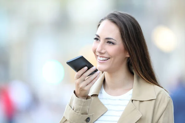 Szczęśliwa kobieta za pomocą rozpoznawania głosu na telefon komórkowy — Zdjęcie stockowe