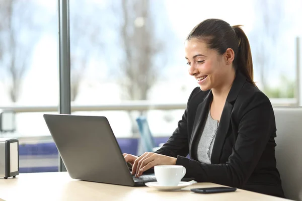 Happy businesswoman using a laptop in a bar — Stock Photo, Image