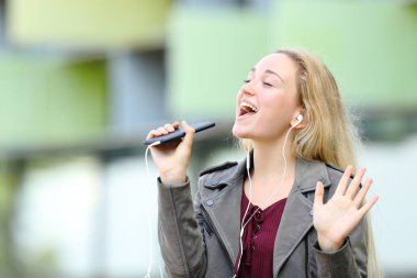 Genç kız akıllı telefon kullanarak karaoke şarkı