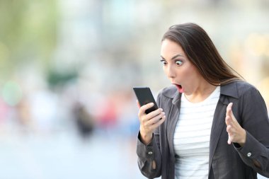 Şaşırmış kadın akıllı telefon içeriği kontrol