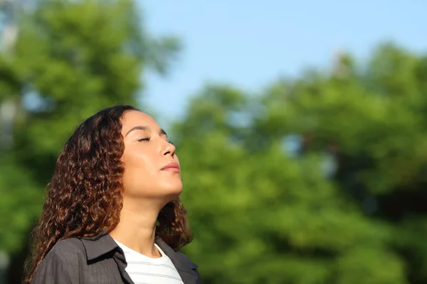 Розслаблена змішана раса жінка дихає свіжим повітрям — стокове фото