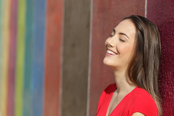 Mujer feliz apoyada en una pared colorida en la calle — Foto de Stock