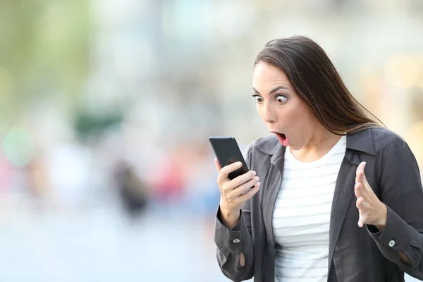 Удивительная женщина проверяет контент на смартфоне — стоковое фото