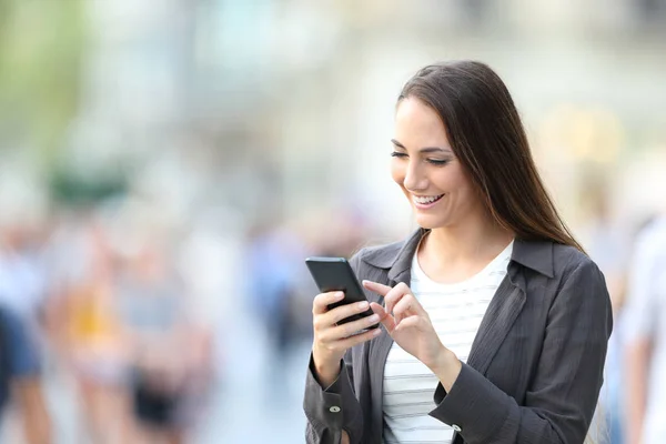 Mulher casual feliz verificando o conteúdo do telefone inteligente — Fotografia de Stock