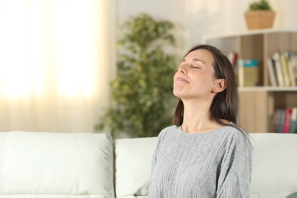 Розслаблена жінка вдома дихає свіжим повітрям — стокове фото