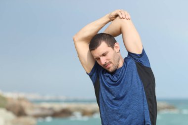 Sahilde spor dan sonra uzanan koşucu