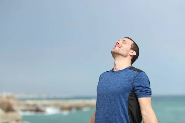 Spor öncesi plajda temiz hava soluan mutlu koşucu — Stok fotoğraf