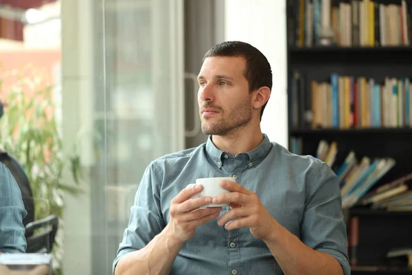 Avslappnad man tittar genom ett fönster i ett kafé — Stockfoto