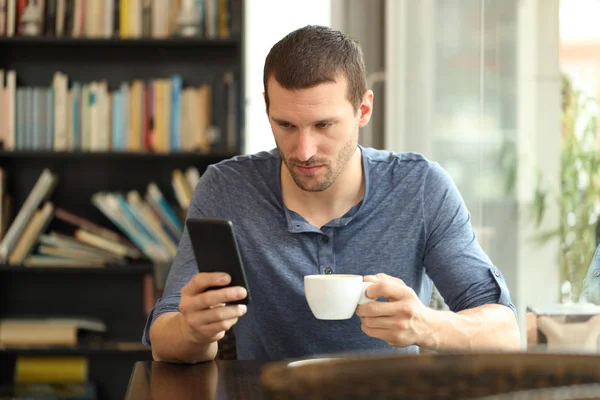 Seriöser Mann checkt Smartphone in Coffeeshop — Stockfoto