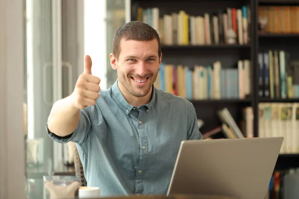 Щасливий дорослий чоловік з ноутбуком з великими пальцями вгору — стокове фото