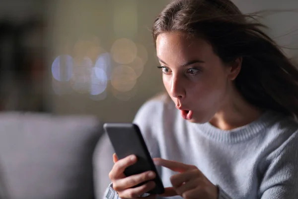 Verbaasd vrouw het controleren van de telefoon snelheid thuis — Stockfoto
