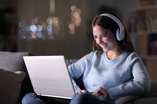 Gadis bahagia menonton dan mendengarkan video di laptop — Stok Foto