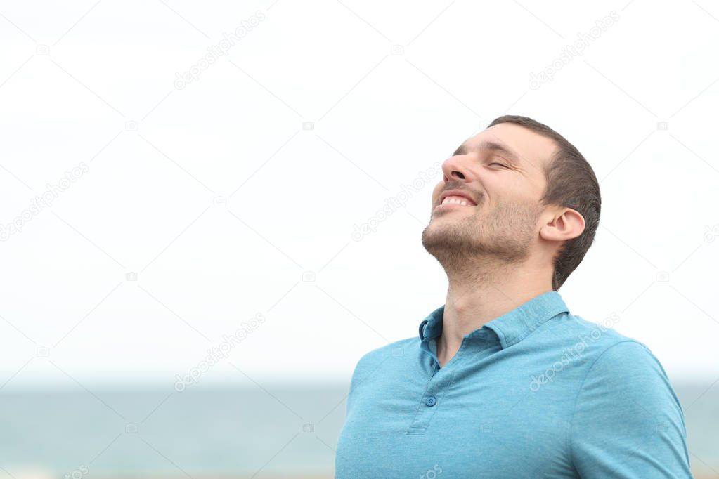 Handsome adult man breathing fresh air on the beach
