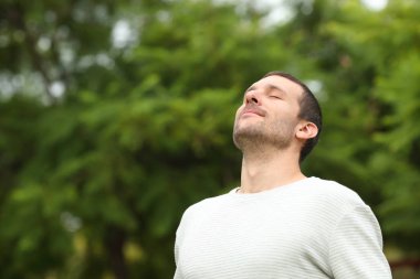 Rahat yetişkin bir adam ormanda temiz hava soluyor.