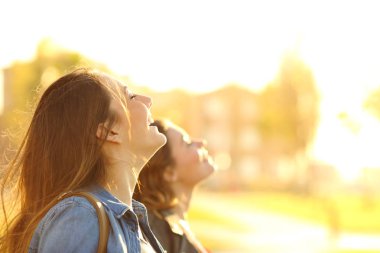 Gün batımında derin temiz hava soluan arkadaşlarının profili
