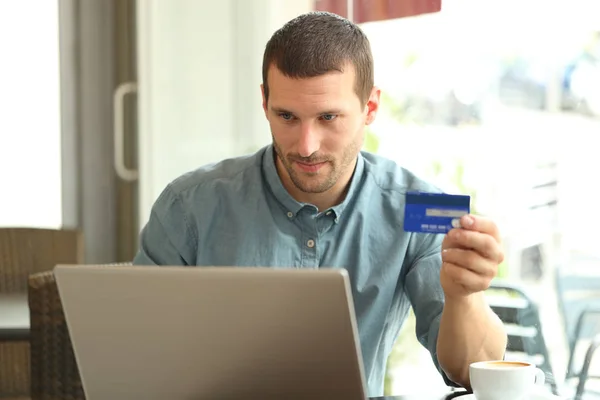 Homme sérieux achetant avec carte de crédit et ordinateur portable dans un bar — Photo