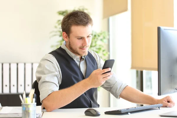 Executive checking smart phone message at office — Stock Photo, Image