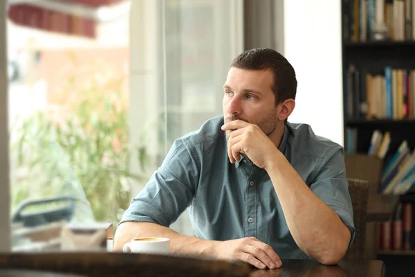 Pensive man i ett kafé tittar genom ett fönster — Stockfoto