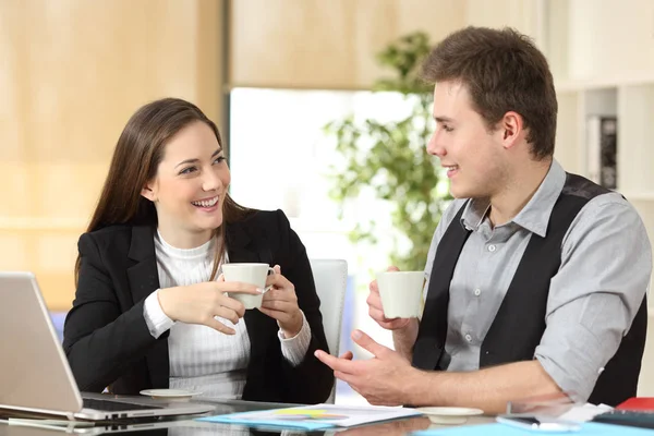 Happy office workers drinking coffee and talking